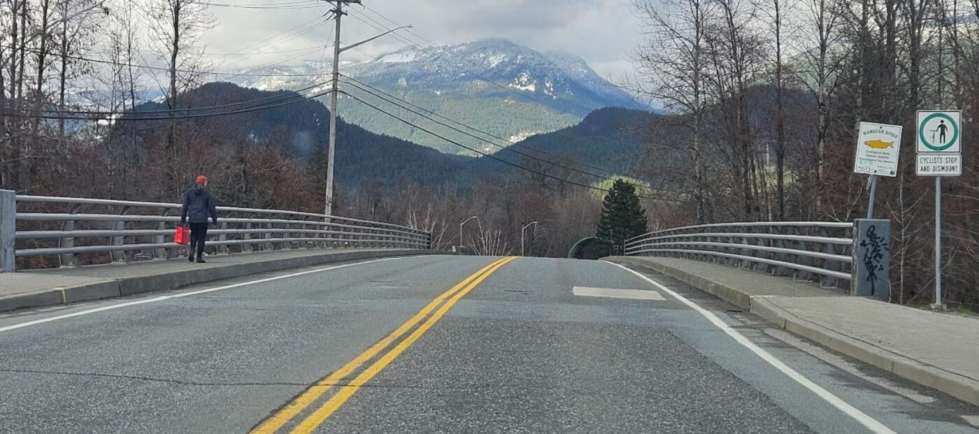 Man walking on Mamquam Bridge in Squamish.