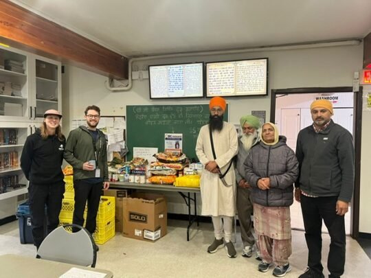 People standing around donated food boxes.